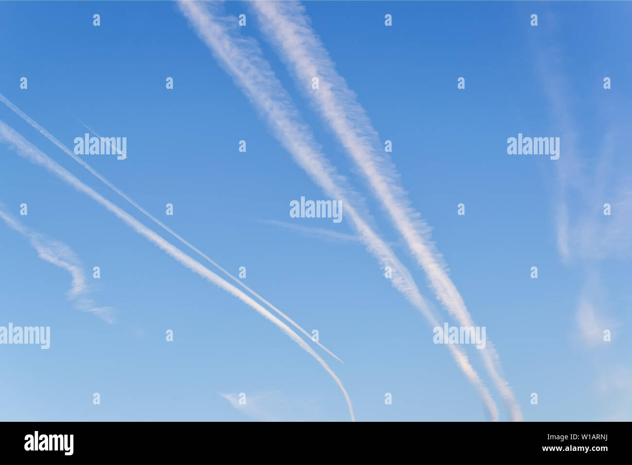 Getti di aereo nel cielo blu. Molte tracce di aereo in un colore blu cielo chiaro su un giorno. Sky con tracce di bianco. Foto Stock