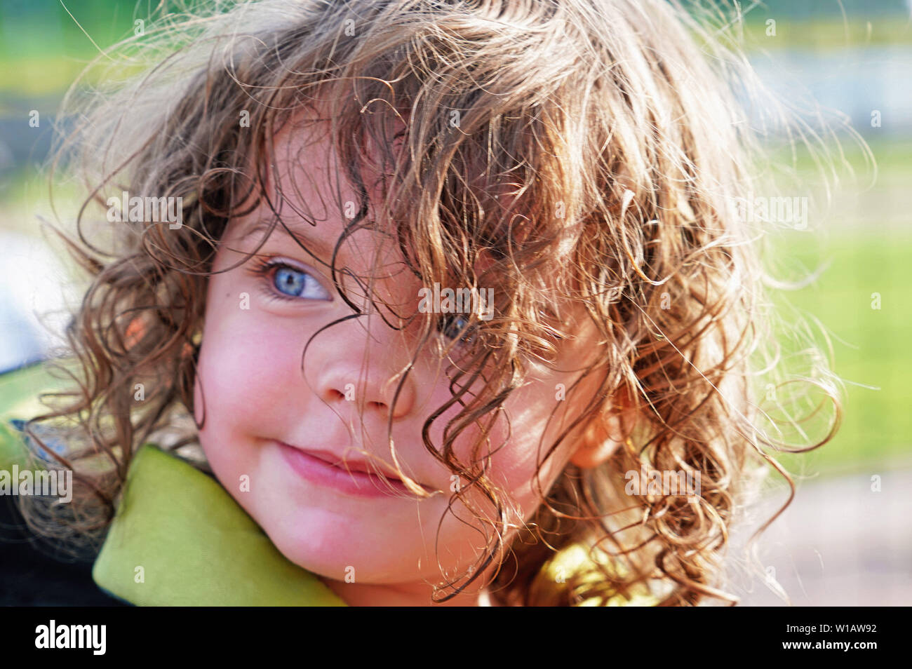 Mondana bambina di tre anni con gli occhi blu e capelli ricci Foto Stock