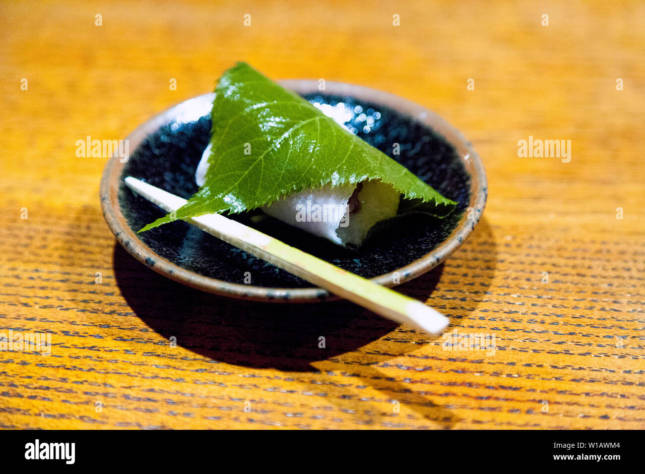 Sakuramochi wagashi dolce giapponese consistente di colore rosa torta di riso con pasta di fagiolo rossa avvolto in un decapato cherry blossom leaf Foto Stock