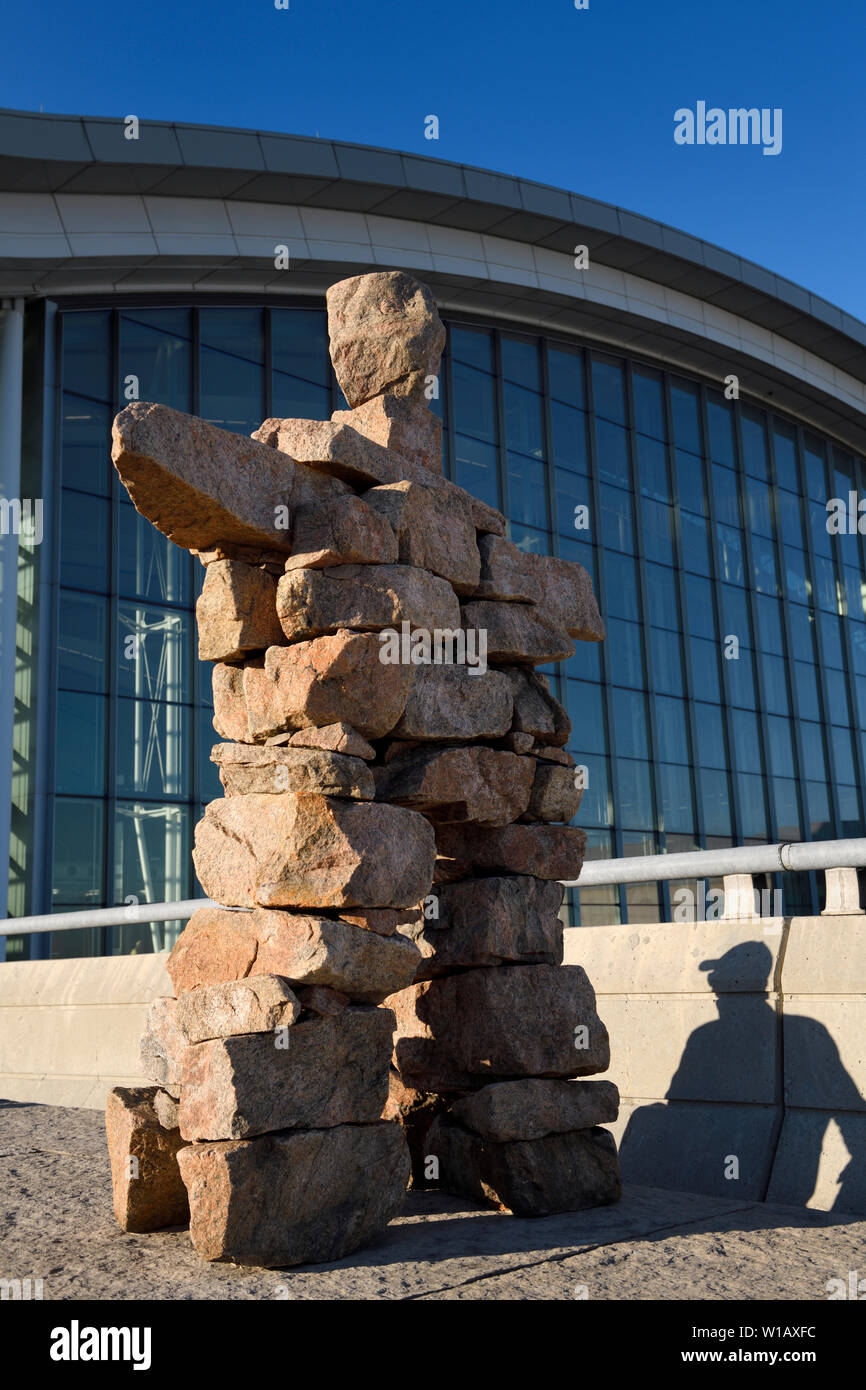 Inukshuk Inuit red statua di pietra con ombra dell uomo al Pearson International Airport Terminal 1 Toronto Canada in alba Foto Stock
