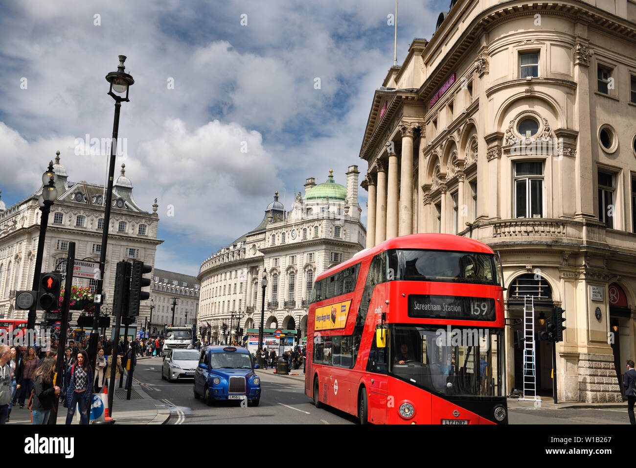 Bus rosso e blu taxi a Coventry e Haymarket strade con il quadrante e il Padiglione di Londra a Piccadilly Circus Westminster London Inghilterra England Foto Stock