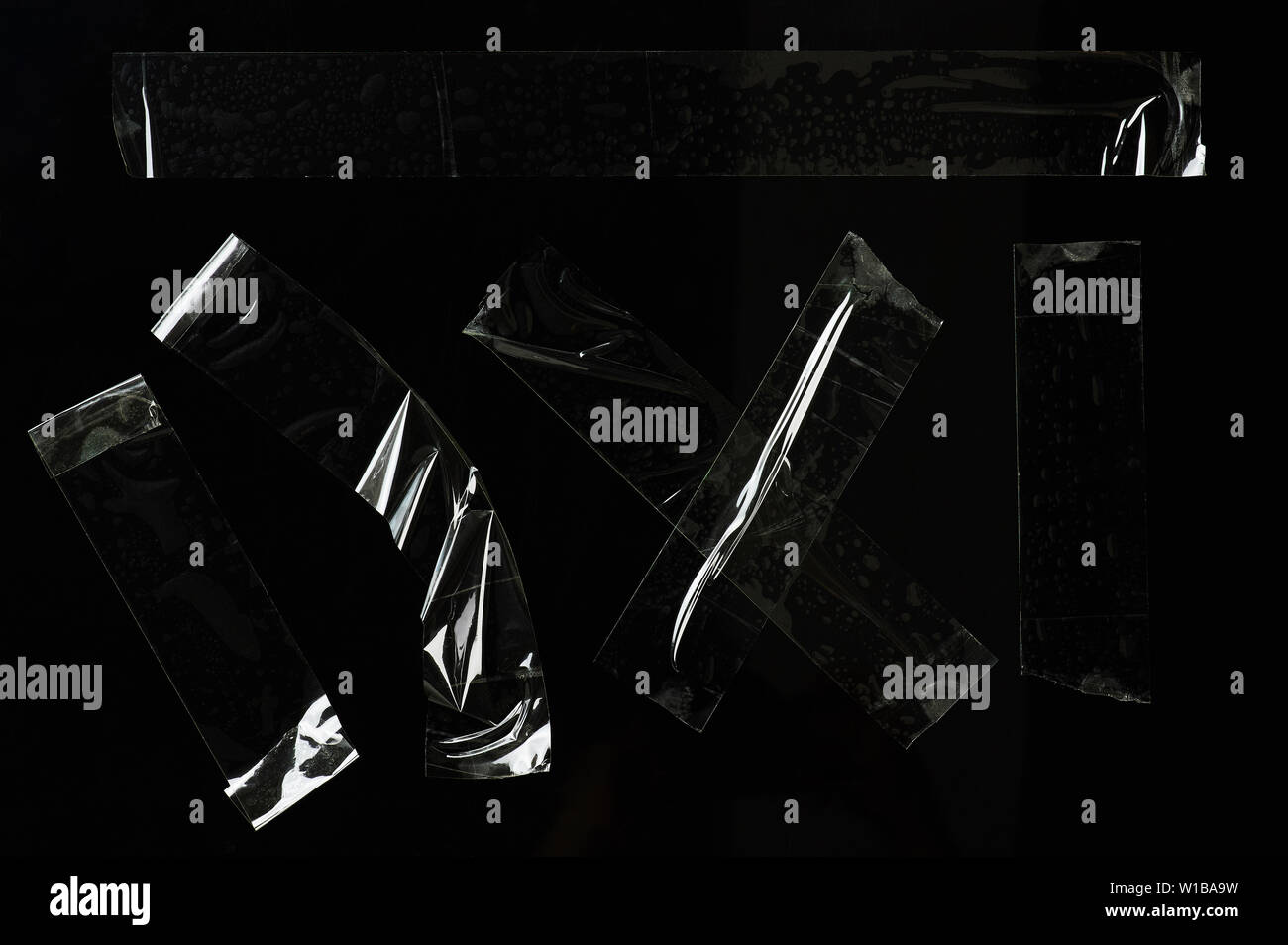 Set di nastro adesivo trasparente pezzi isolati su sfondo nero Foto Stock