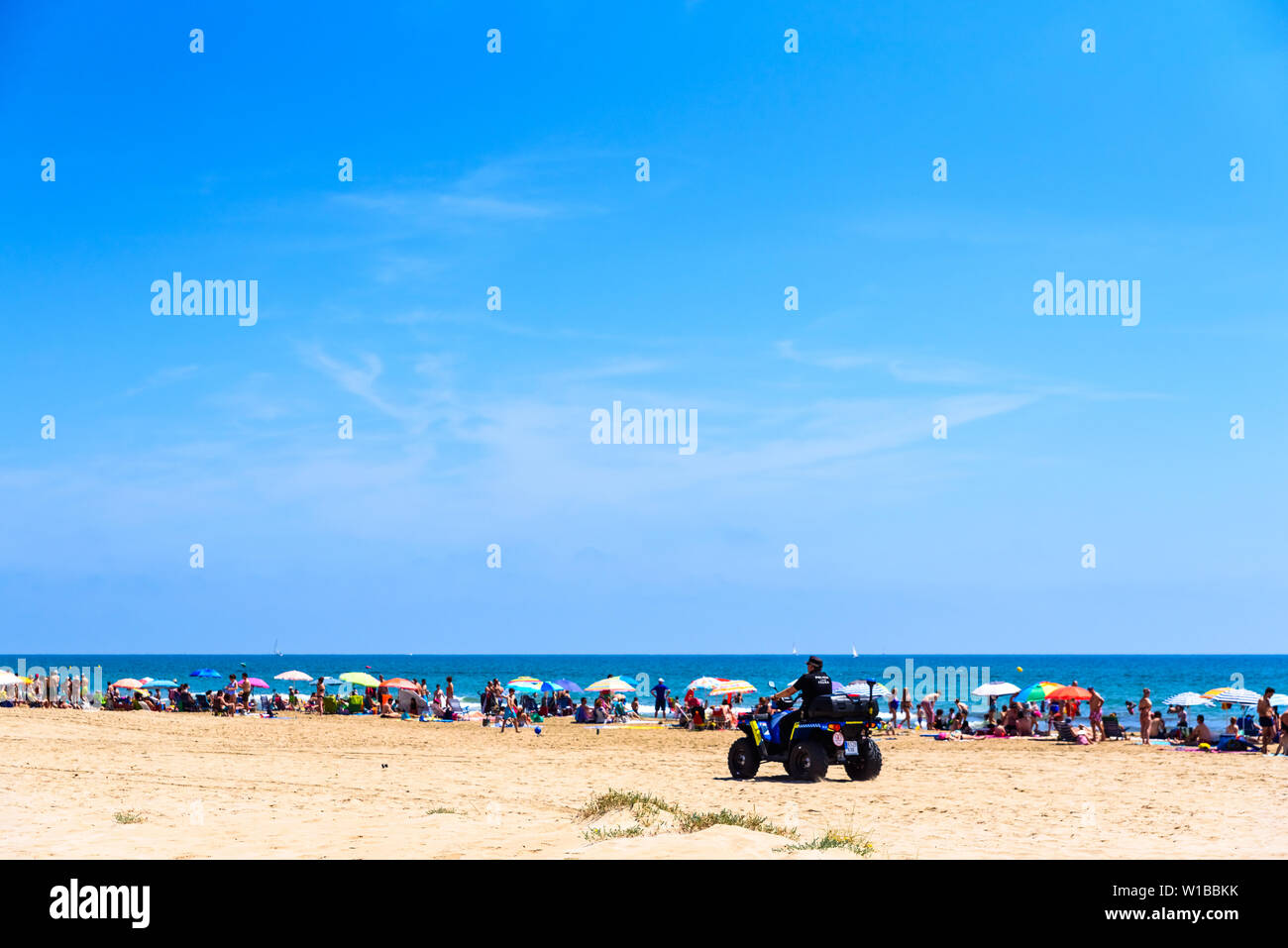 Valencia, Spagna - 23 Giugno 2019: la polizia in quad di pattugliamento per una spiaggia piena di turisti e villeggianti per evitare furti e rapine tipico dell'summe Foto Stock