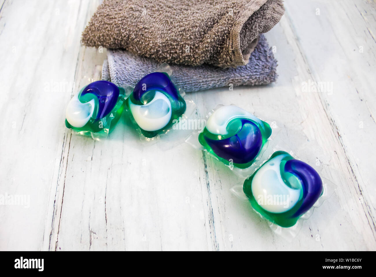 Servizio lavanderia giorno - detergente per lavanderia baccello su un servizio lavanderia tavolo pieghevole con washcloths. Foto Stock
