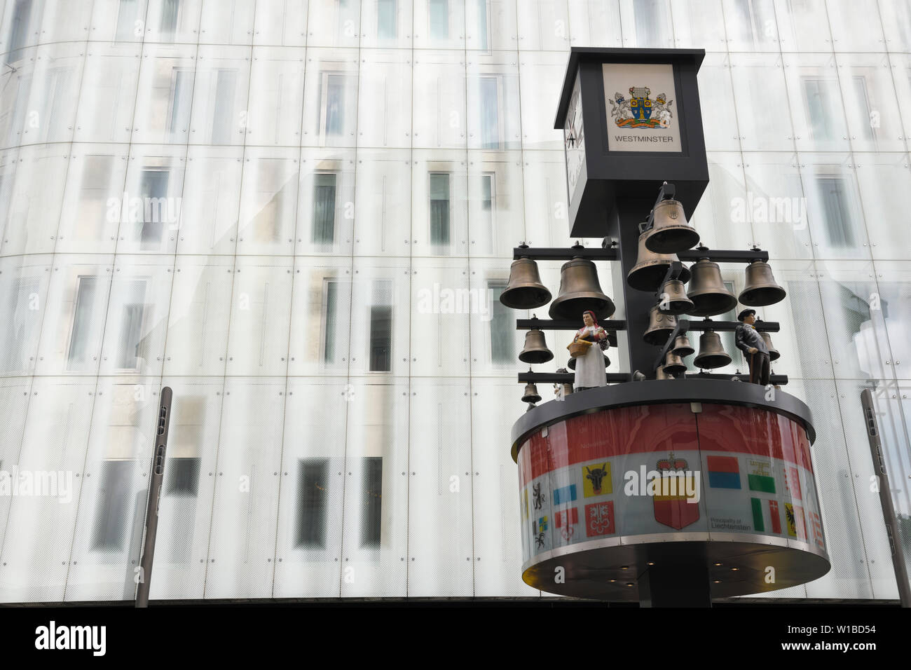 Glockenspiel svizzero a Leicester Square con M&M's mondo moderno edificio di vetro in background a Westminster London Inghilterra England Foto Stock