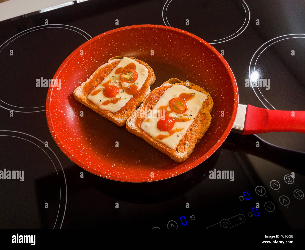 Pane nella Red Padella sul fornello a induzione Foto Stock