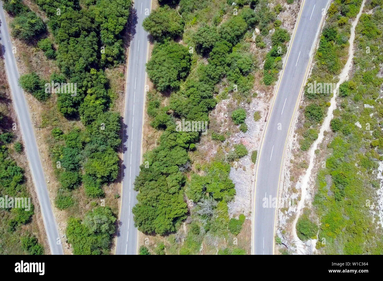 Strada di montagna circondata da lussureggiante foresta verde, immagine aerea. Foto Stock