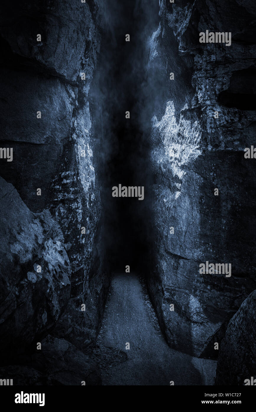 Dark stretto, alta rupe, davanti alla grotta di notte il freddo ha un atmosfera orribile Foto Stock