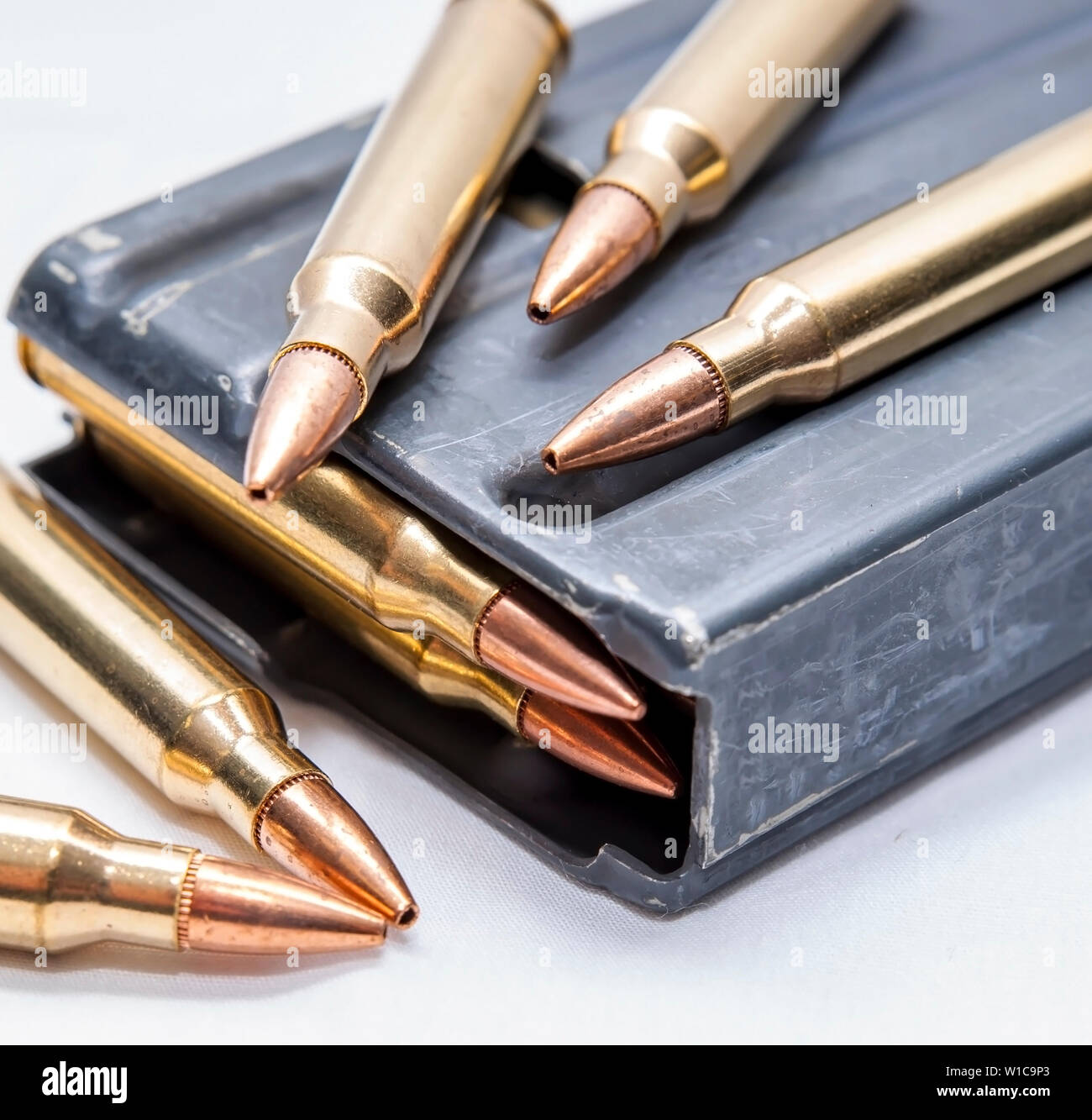223 proiettili calibro lungo con un caricato 223 fucile calibro magazine su sfondo bianco Foto Stock