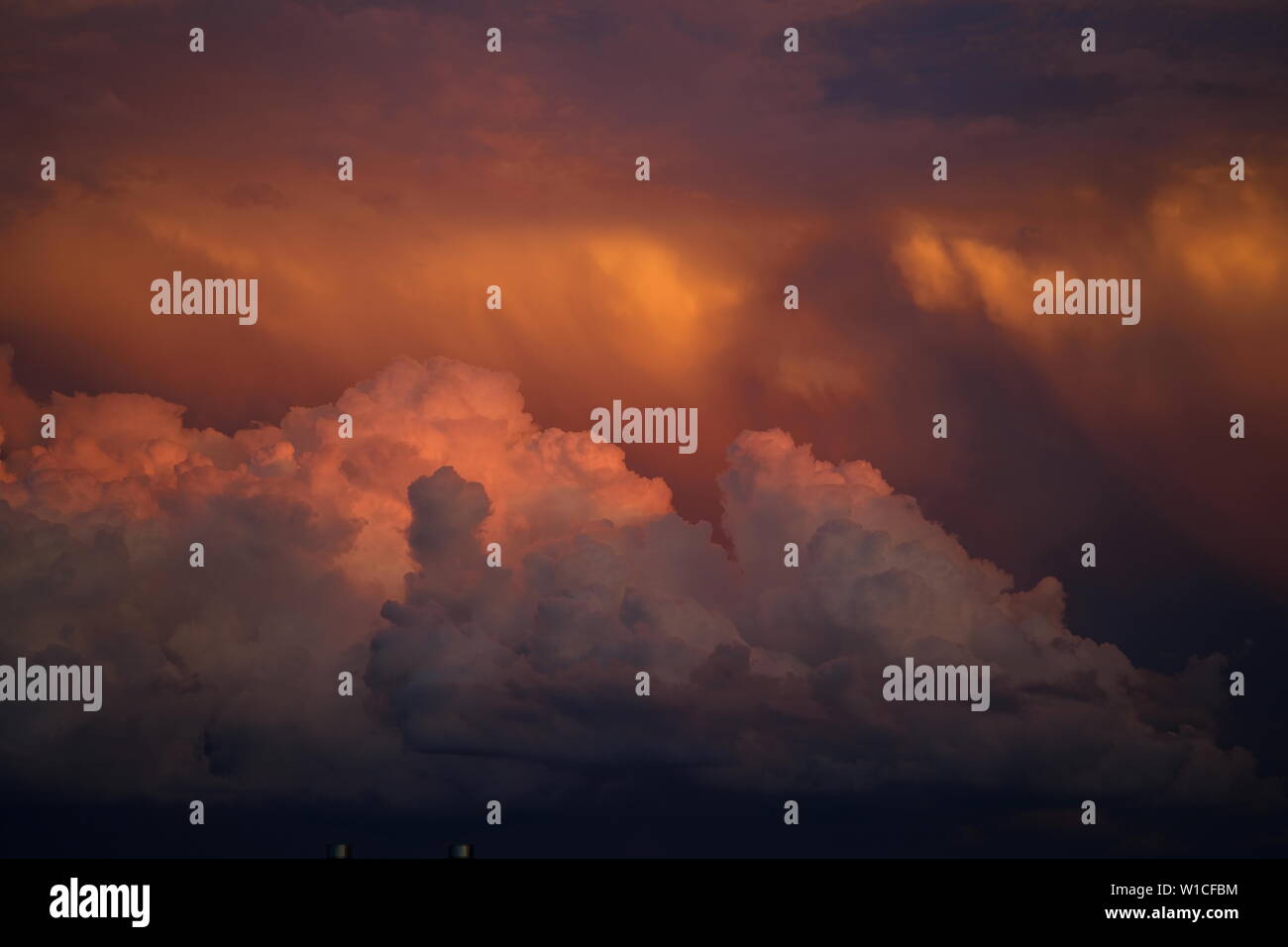 Una bella ma intimidatorio arancione tramonto combinazione colorati di imminente nuvole temporalesche. Foto Stock
