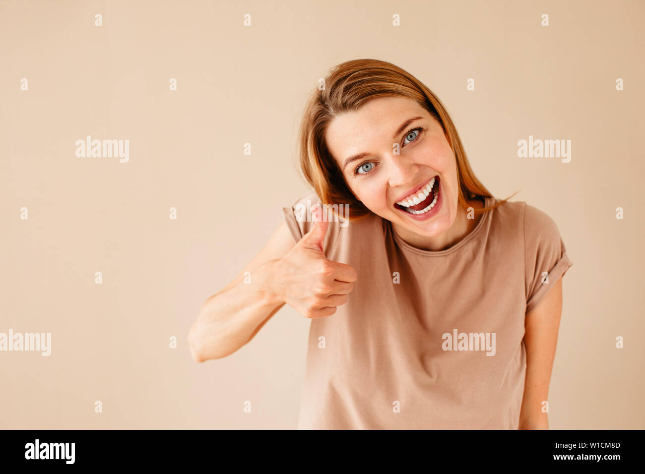 Excited donna gesticolando pollice in alto Foto Stock