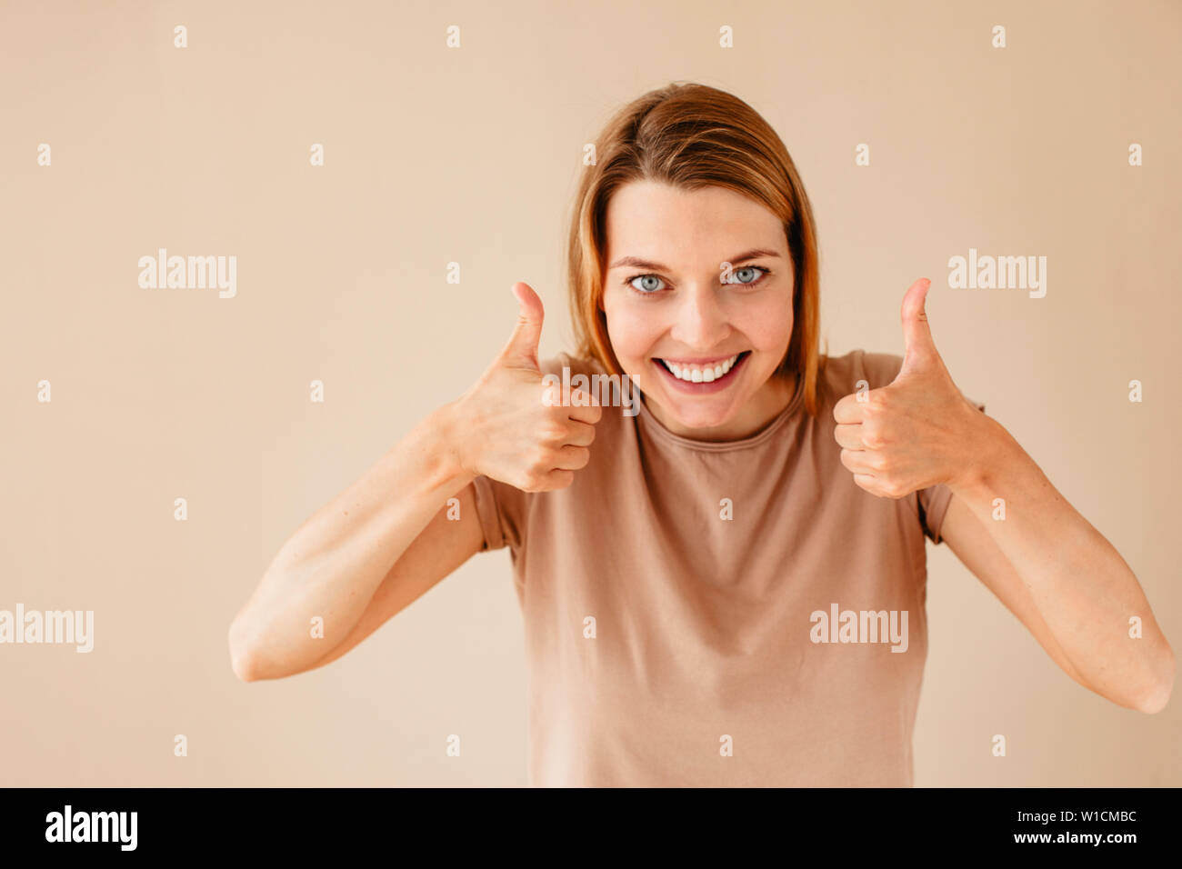 Excited donna gesticolando pollice in alto Foto Stock