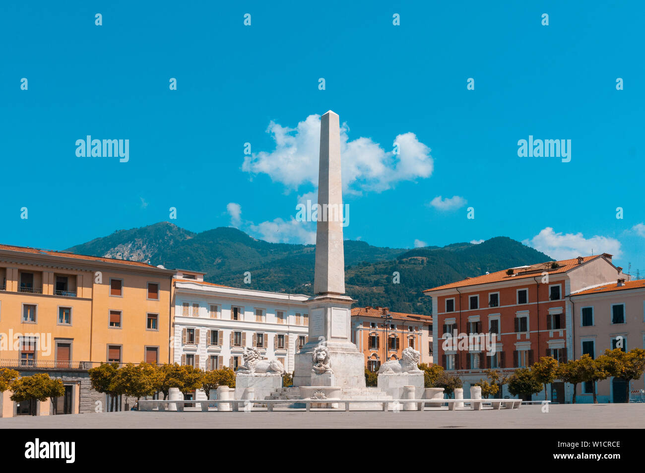 Massa, Italia. Piazza Aranci (arance piazza), la piazza principale della città, caratterizzata da una doppia fila di alberi di arancio, l'obelisco al centro del Foto Stock