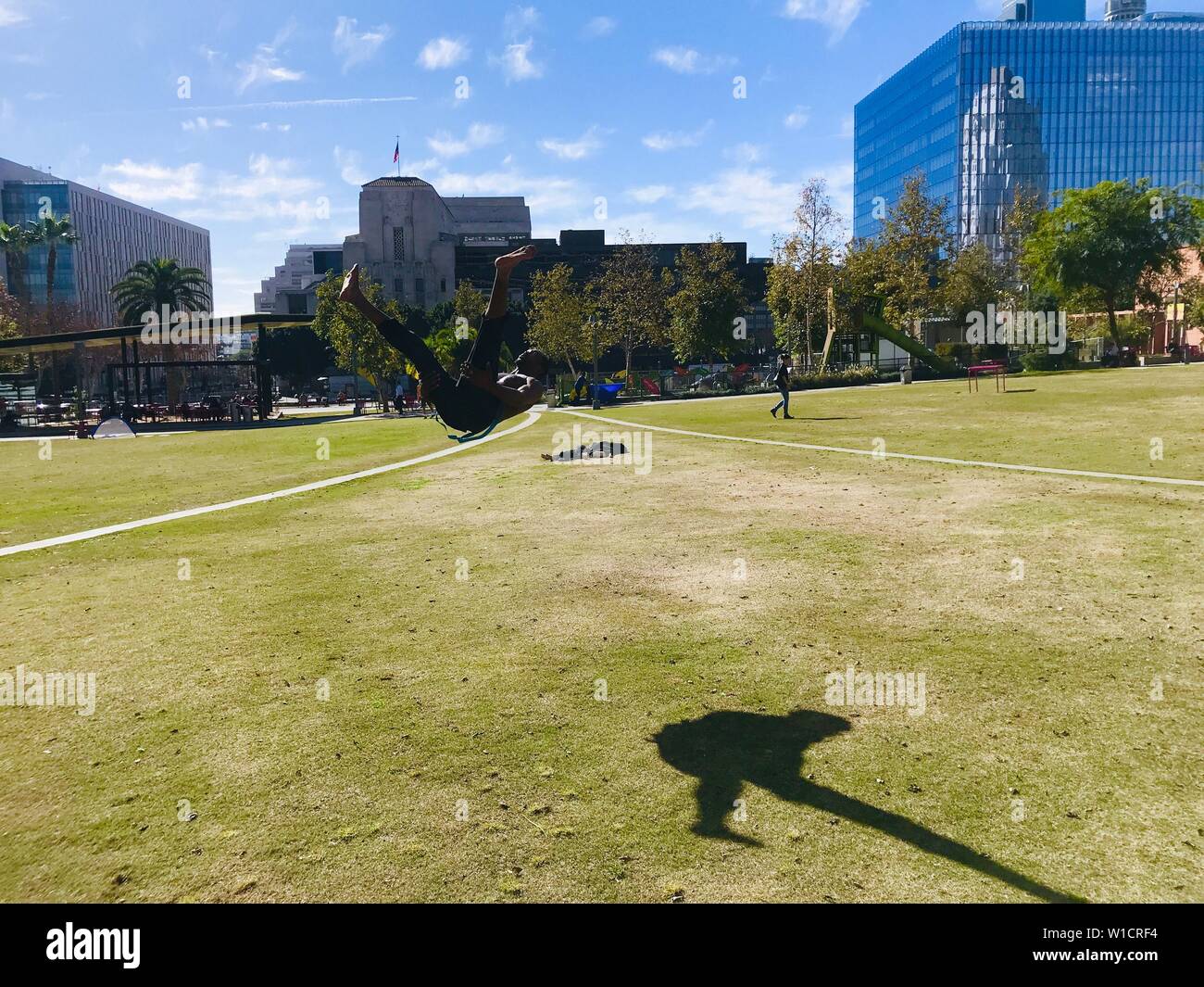 Un uomo che usa la sua pausa pranzo per mettere in pratica la sua agilità e mosse di arti marziali nel parco di fronte al Los Angeles City Hall. Foto Stock