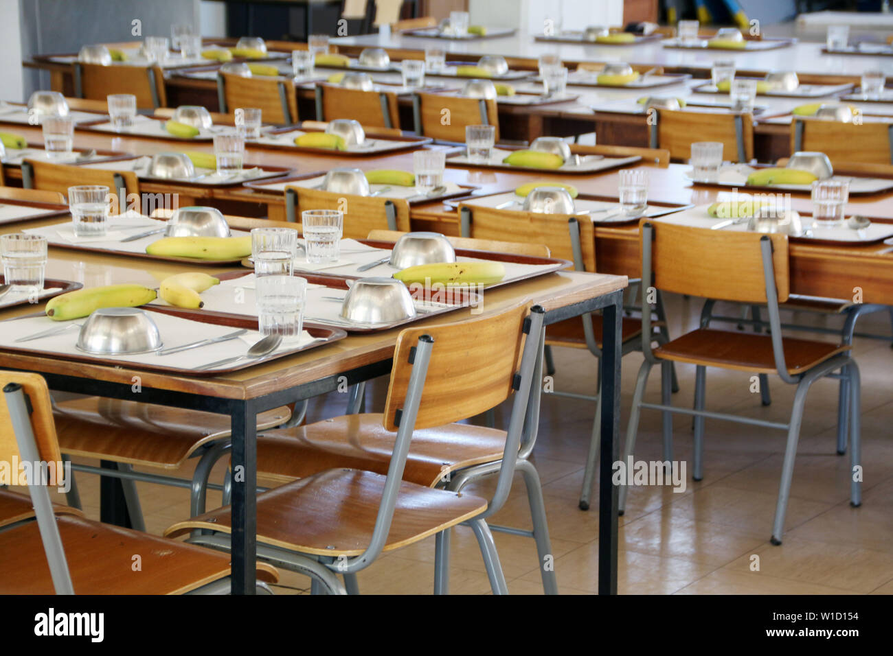 Vista interna di un vuoto che la mensa scolastica con tavoli e sedie. Foto Stock