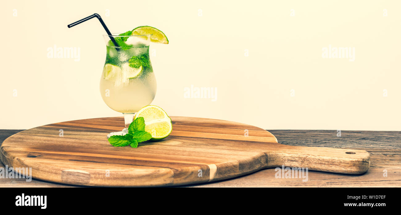 Refeshing bevanda estiva con lime e foglie di menta sulla tavola di legno. Un delizioso cocktail. In stile vintage. Foto Stock