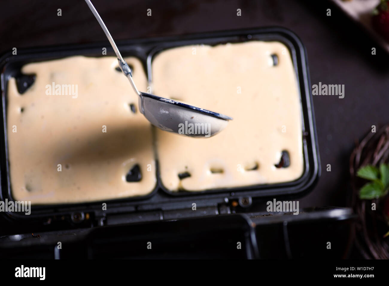 Waffle impasto versando sulla macchina di cottura close up Foto Stock