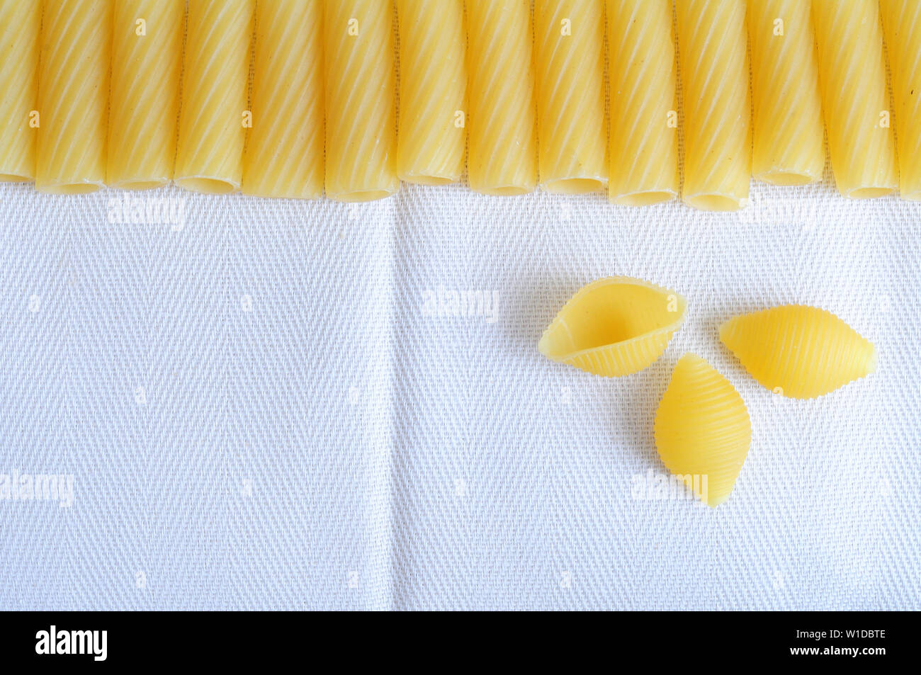 Telaio di materie maccheroni, tipica pasta italiana con tre conchiglie, concept per il cibo italiano o della cucina italiana, grande sala di testo Foto Stock
