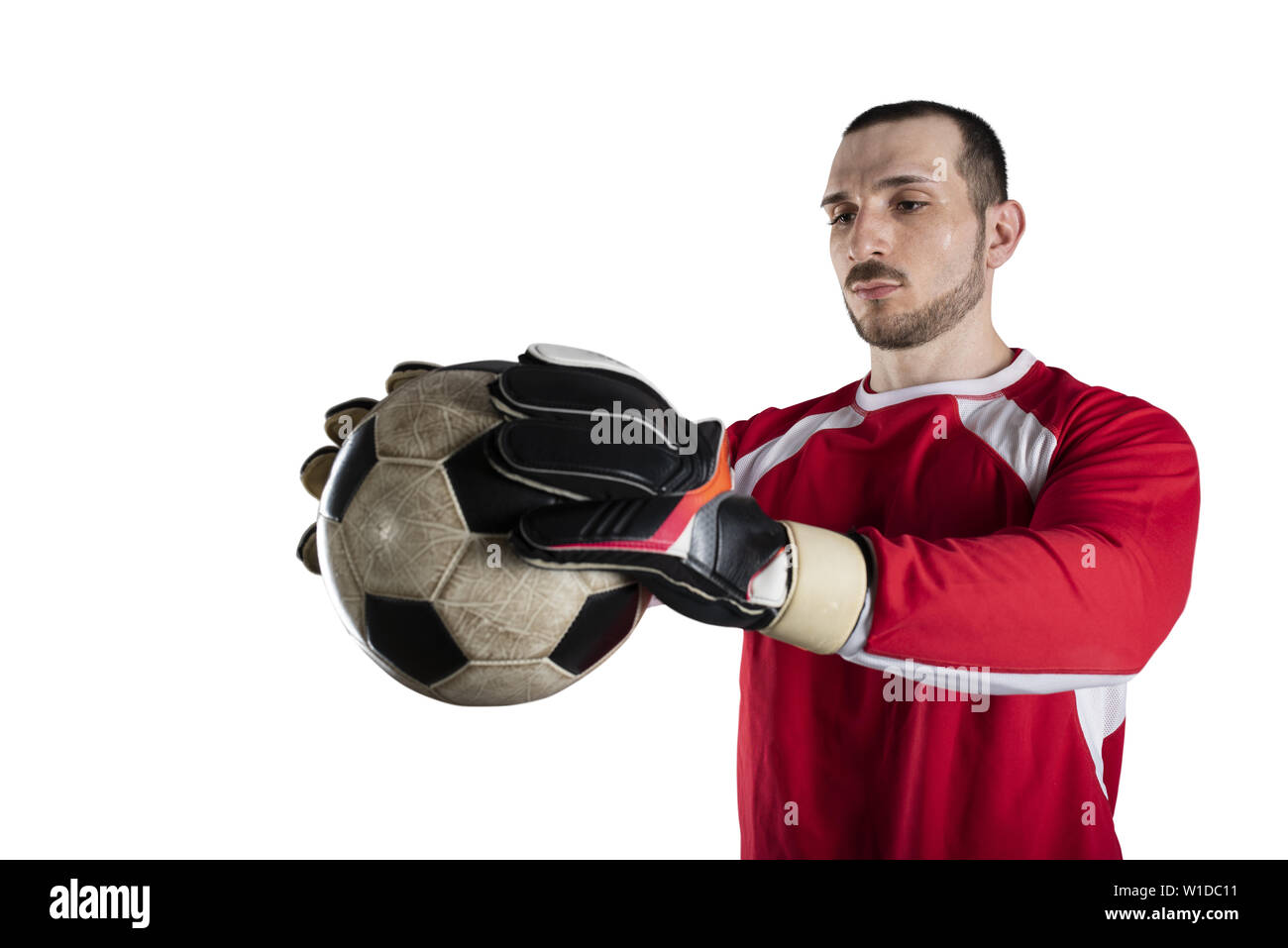 Il portiere tiene la palla nello stadio durante una partita di calcio. Isolato su sfondo bianco Foto Stock