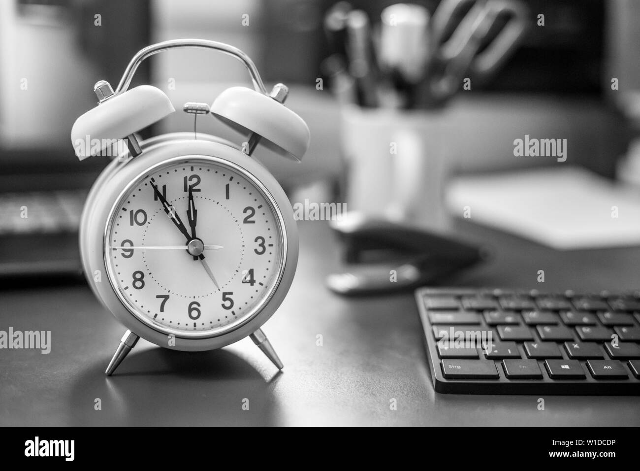 Sveglia sul banco, ufficio roba in sfondo sfocato, scadenze e todos Foto Stock