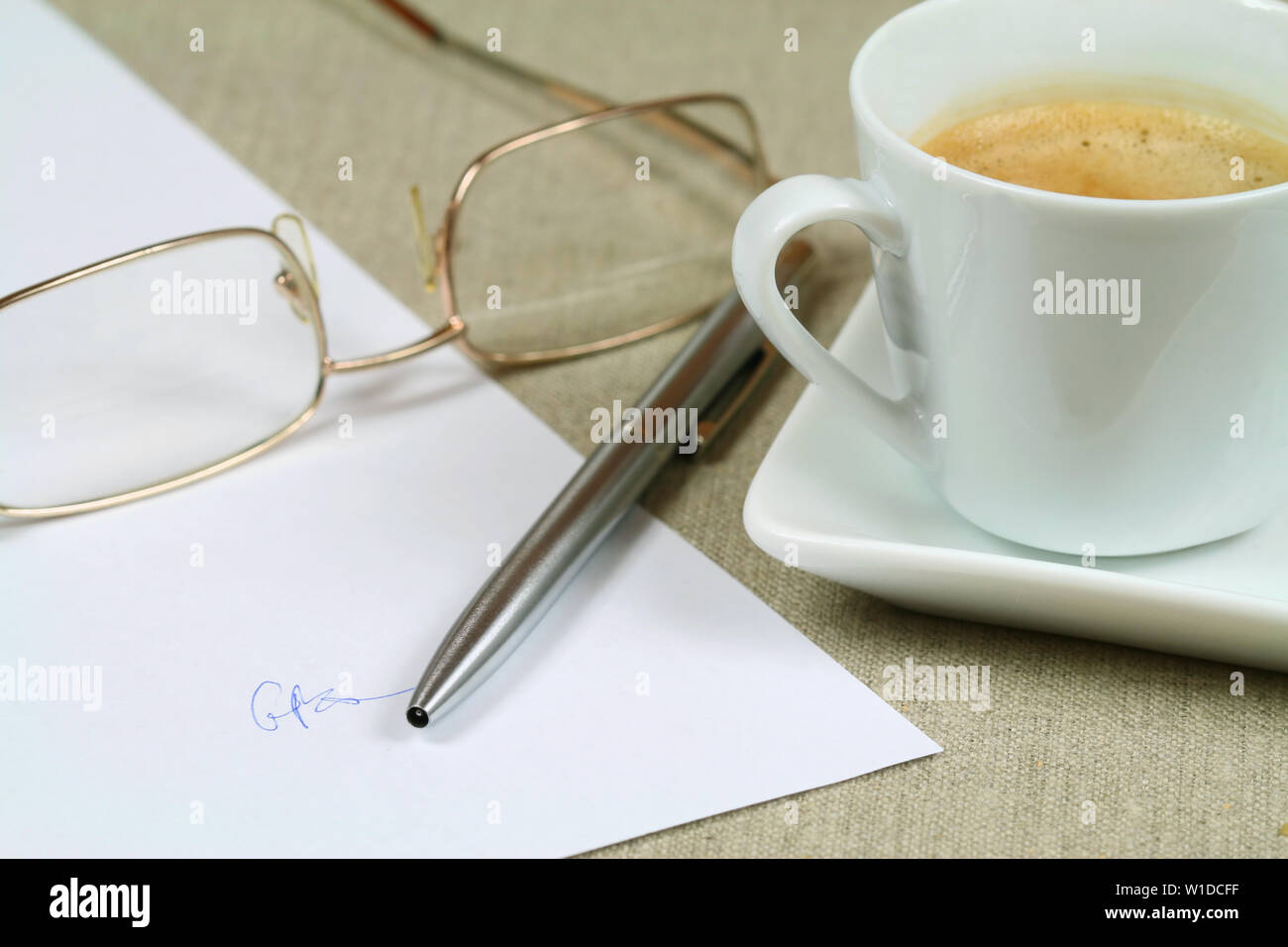 Contratto sottoscritto in blanco, argento penna, bicchieri e tazze di caffè espresso Foto Stock