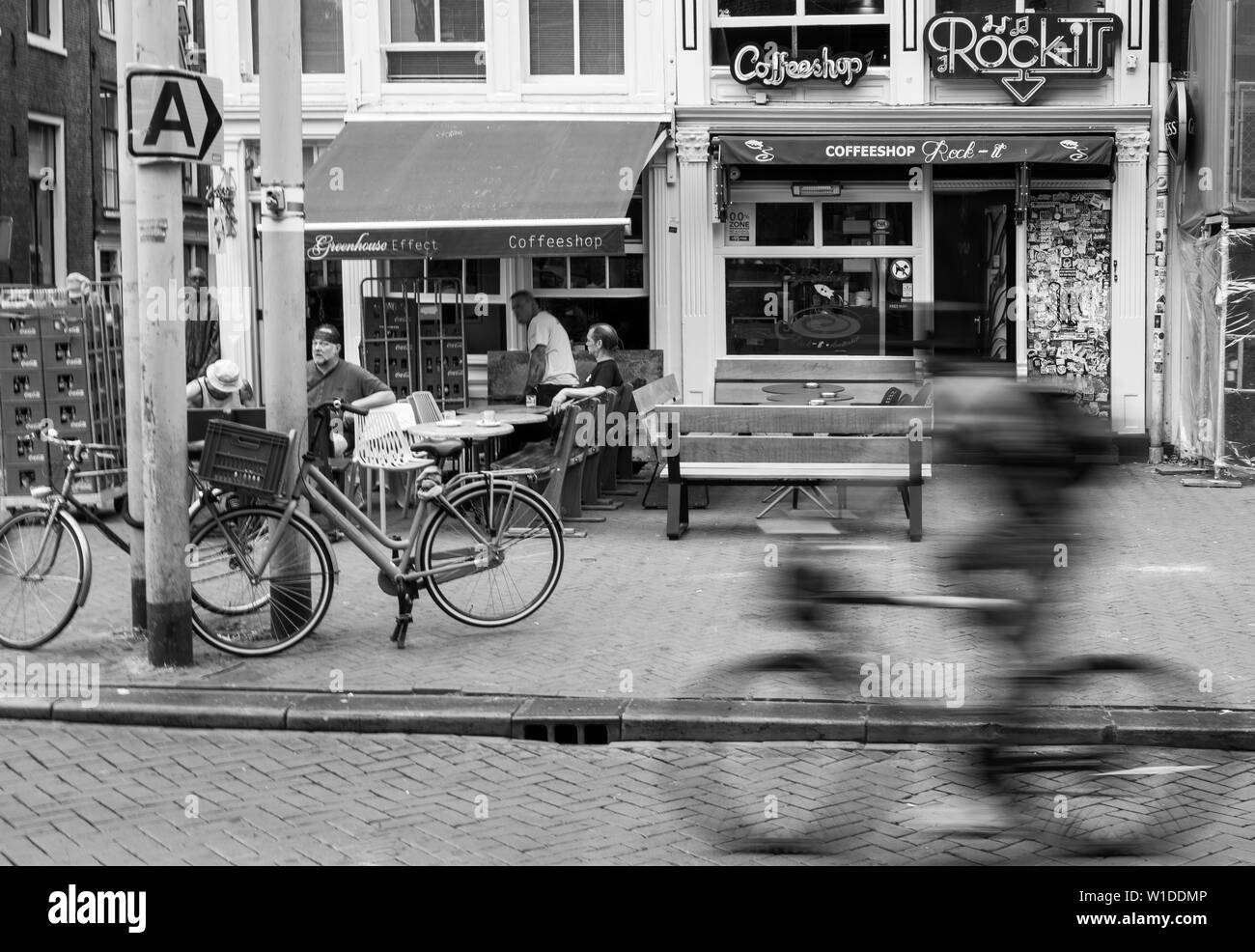 Velocità ciclista passato coffee shop in Amsterdam Foto Stock