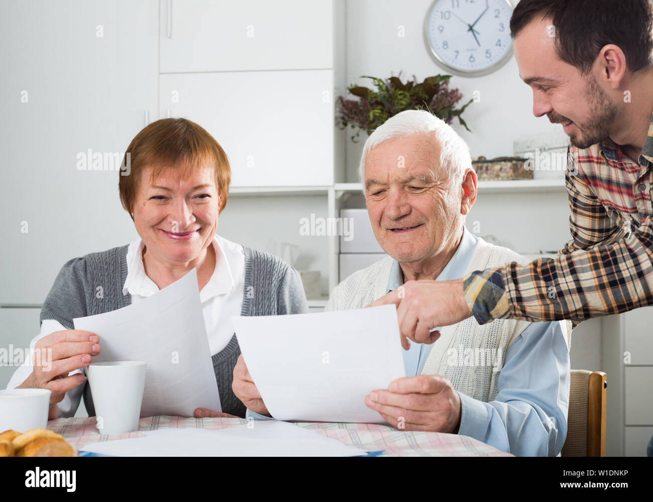 Coppia di anziani e sociale responsabile di reparto compila il questionario Foto Stock