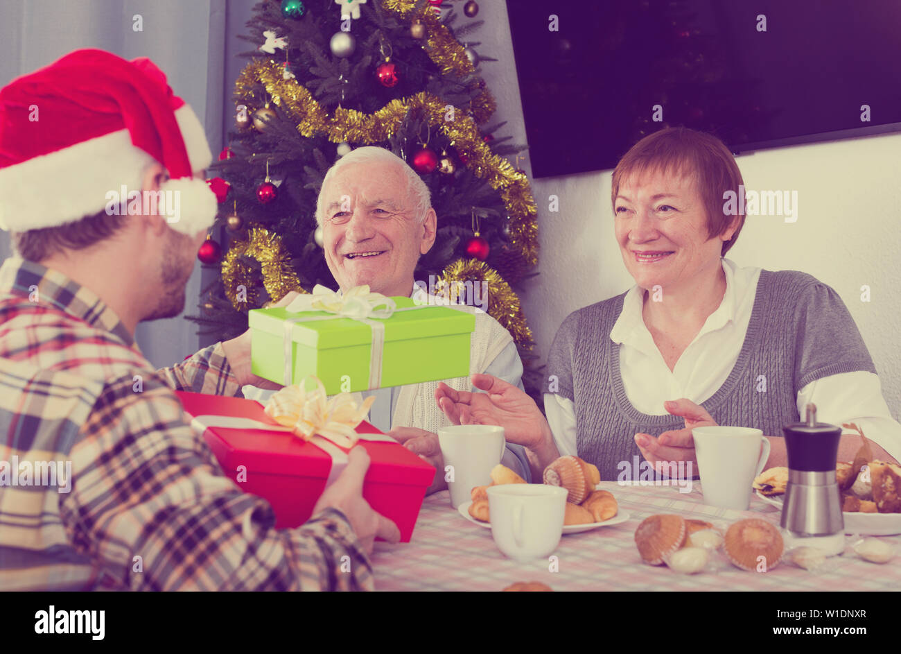 Vecchia coppia ottenere dei regali dal nipote per Natale e Felice Anno Nuovo Foto Stock