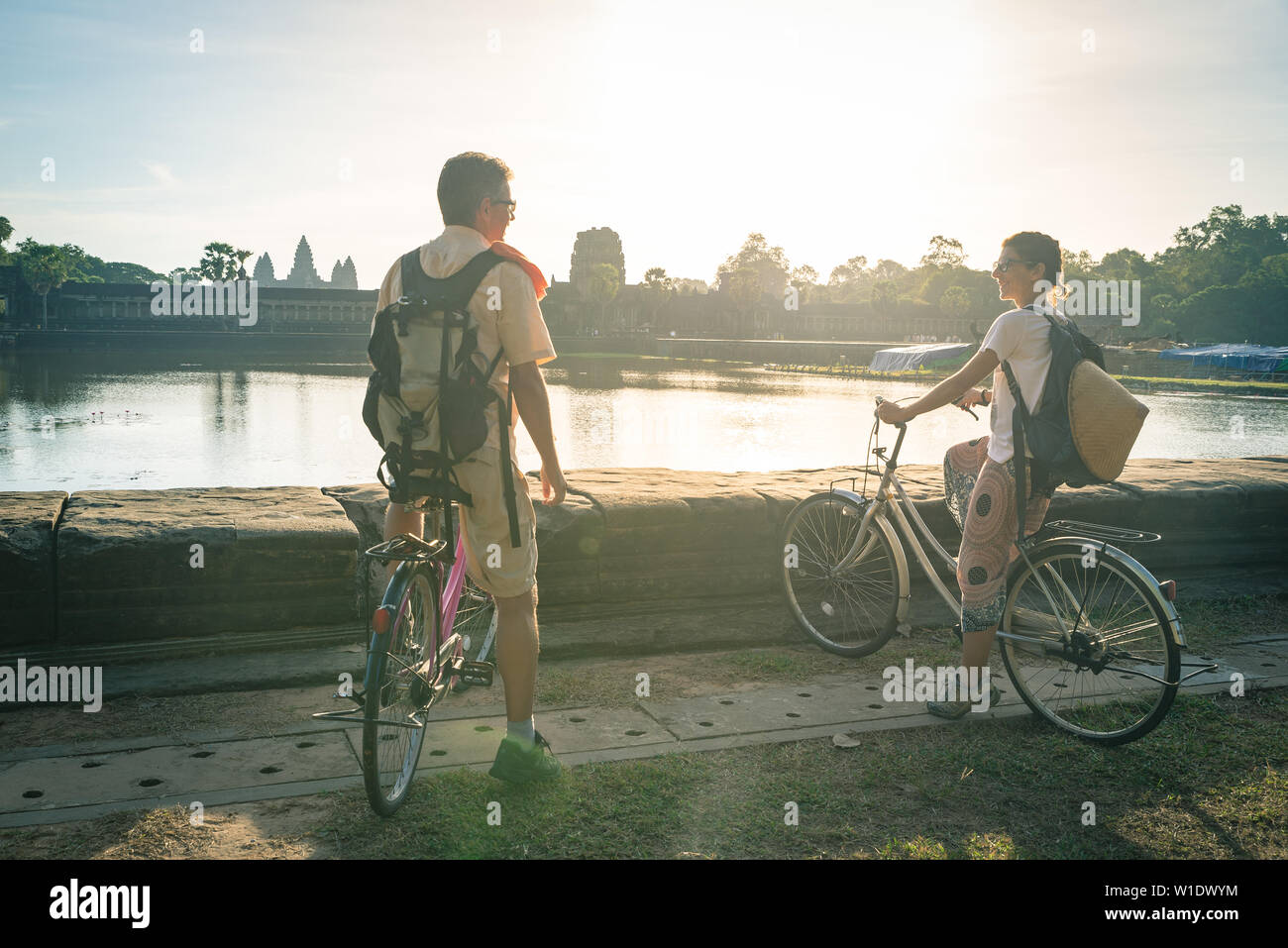 Turista giovane in bicicletta nel tempio di Angkor, Cambogia. Angkor Wat facciata principale riflesso sul laghetto di acqua. Eco-turismo viaggi. Tonica Foto Stock