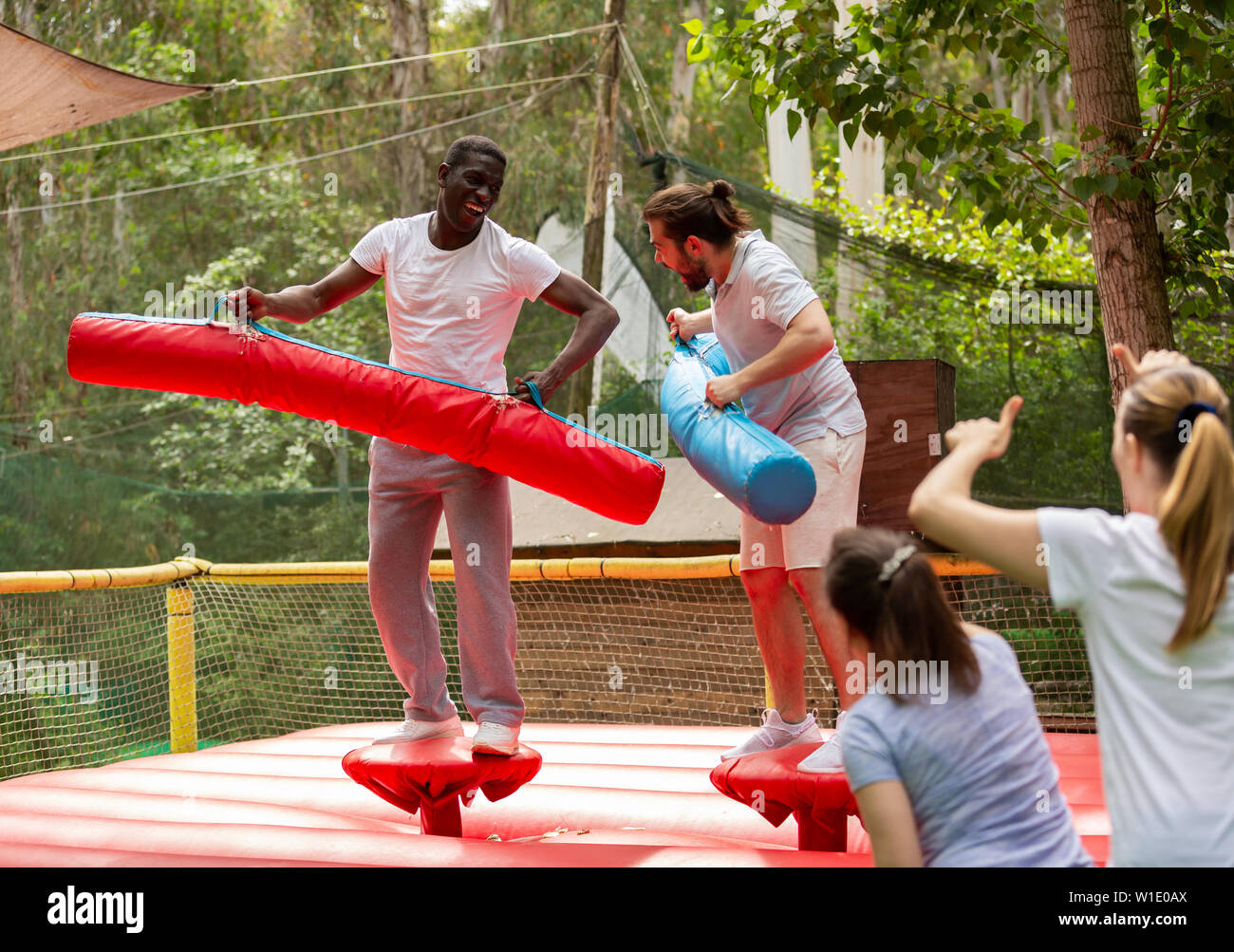 Allegro uomini adulti divertirsi sui gonfiabili lotta gladiator arena all' aperto nel parco di divertimenti Foto stock - Alamy