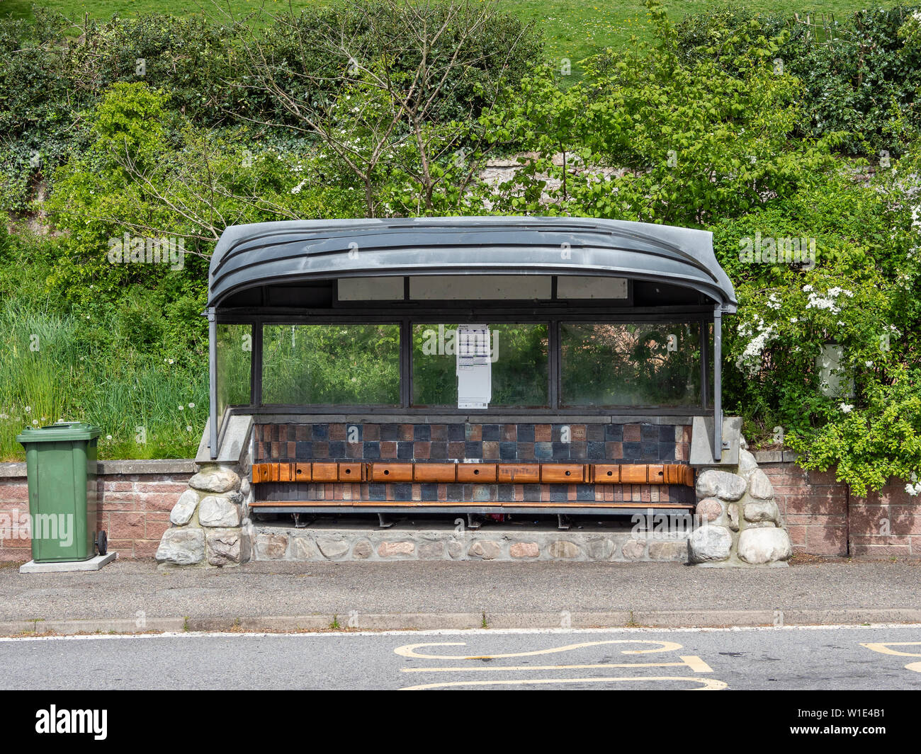 Barca usata come un bus shelter sulla A832 a Avoch, Black Isle, regione delle Highlands, Scozia Foto Stock