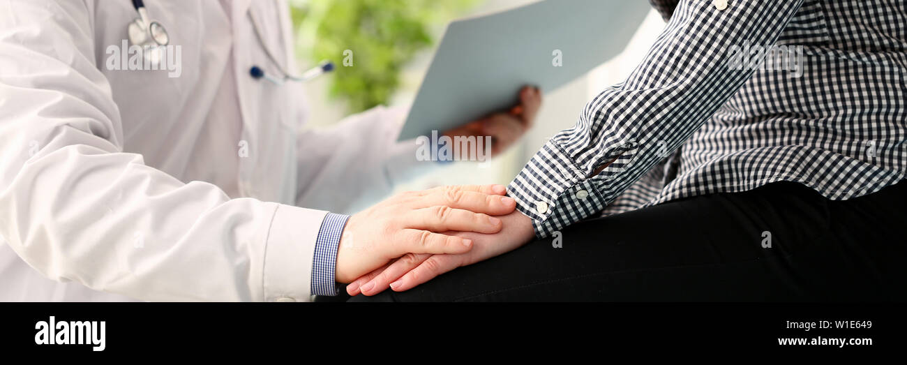 Medico maschio tenere pacient braccio femmina Foto Stock