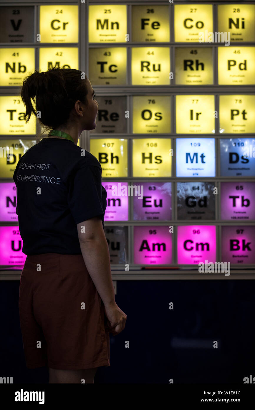 Royal Society Summer Science Exhibition, una giovane donna che guarda un illuminato Tabella Periodica celebra il centocinquantesimo anniversario, London, Regno Unito Foto Stock