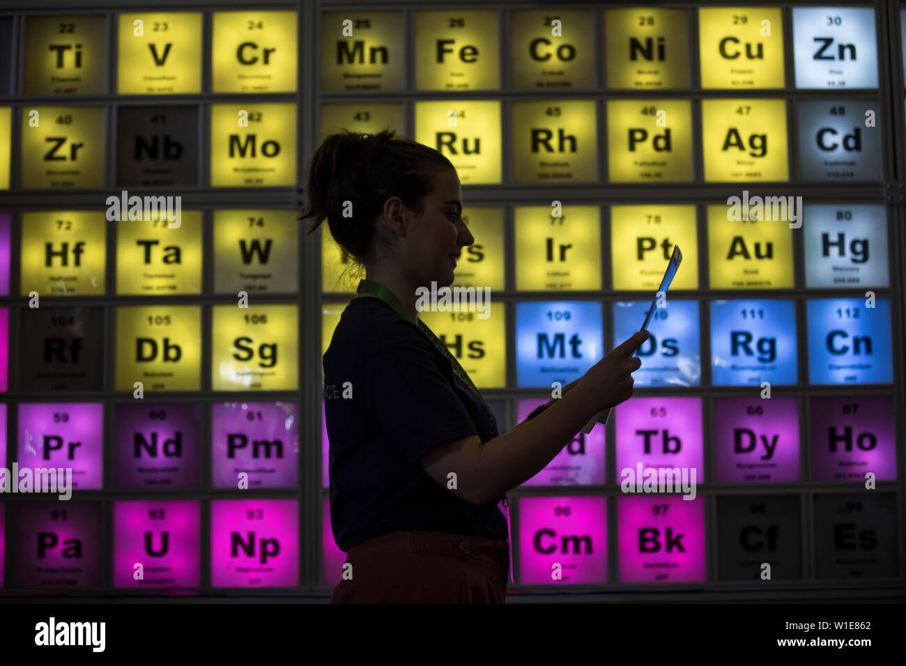 Royal Society Summer Science Exhibition, una giovane donna che guarda un illuminato Tabella Periodica celebra il centocinquantesimo anniversario, London, Regno Unito Foto Stock