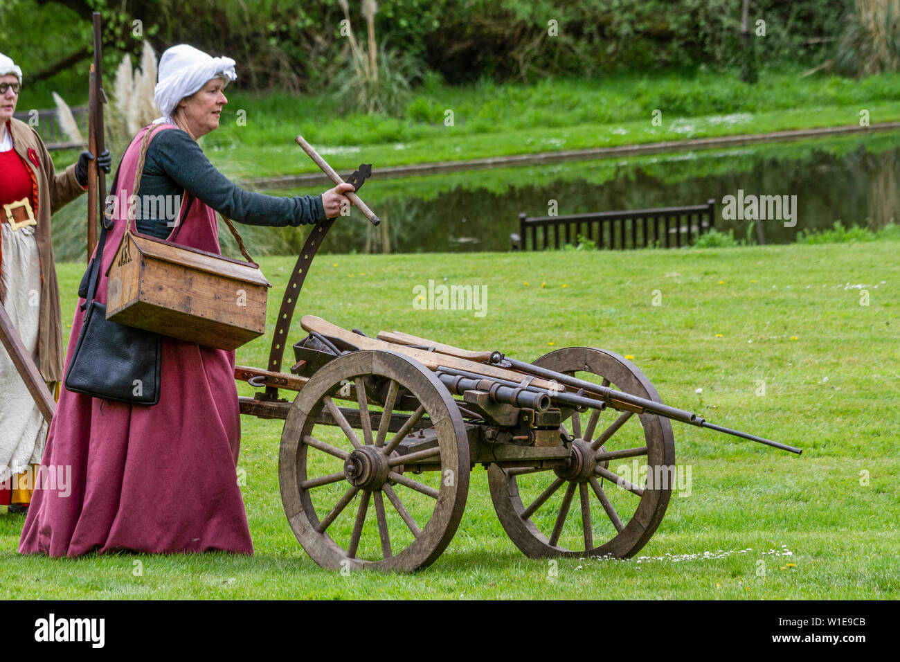 Donna in costume medievale con un cannone Foto Stock