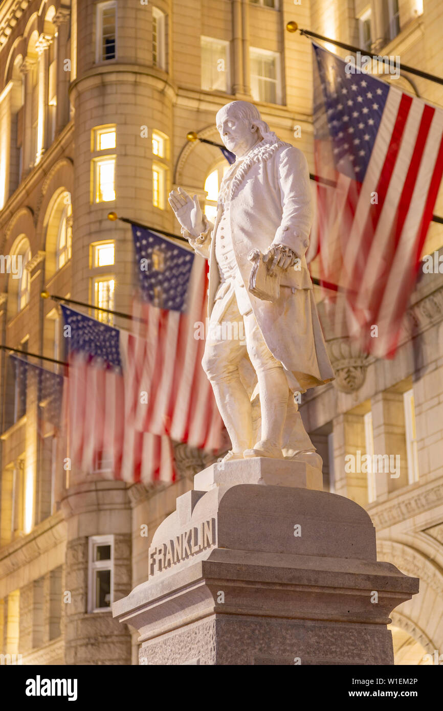 Vista di Benjamin Franklin statua e noi le bandiere di fronte ex Old Post Office Pavilion, Washington D.C., Stati Uniti d'America, America del Nord Foto Stock
