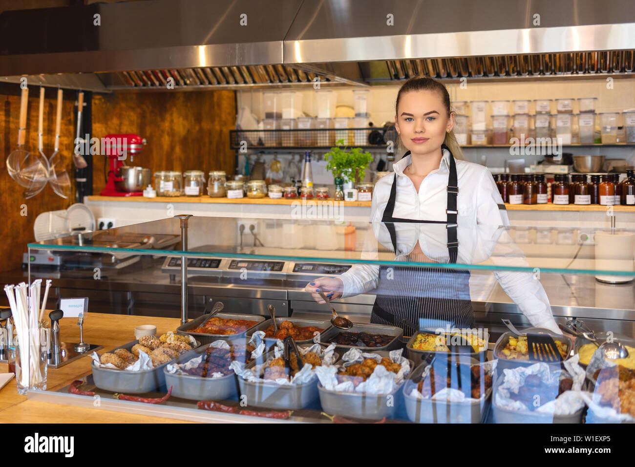 Servizi di catering con cameriera dietro il ristorante counter Foto Stock