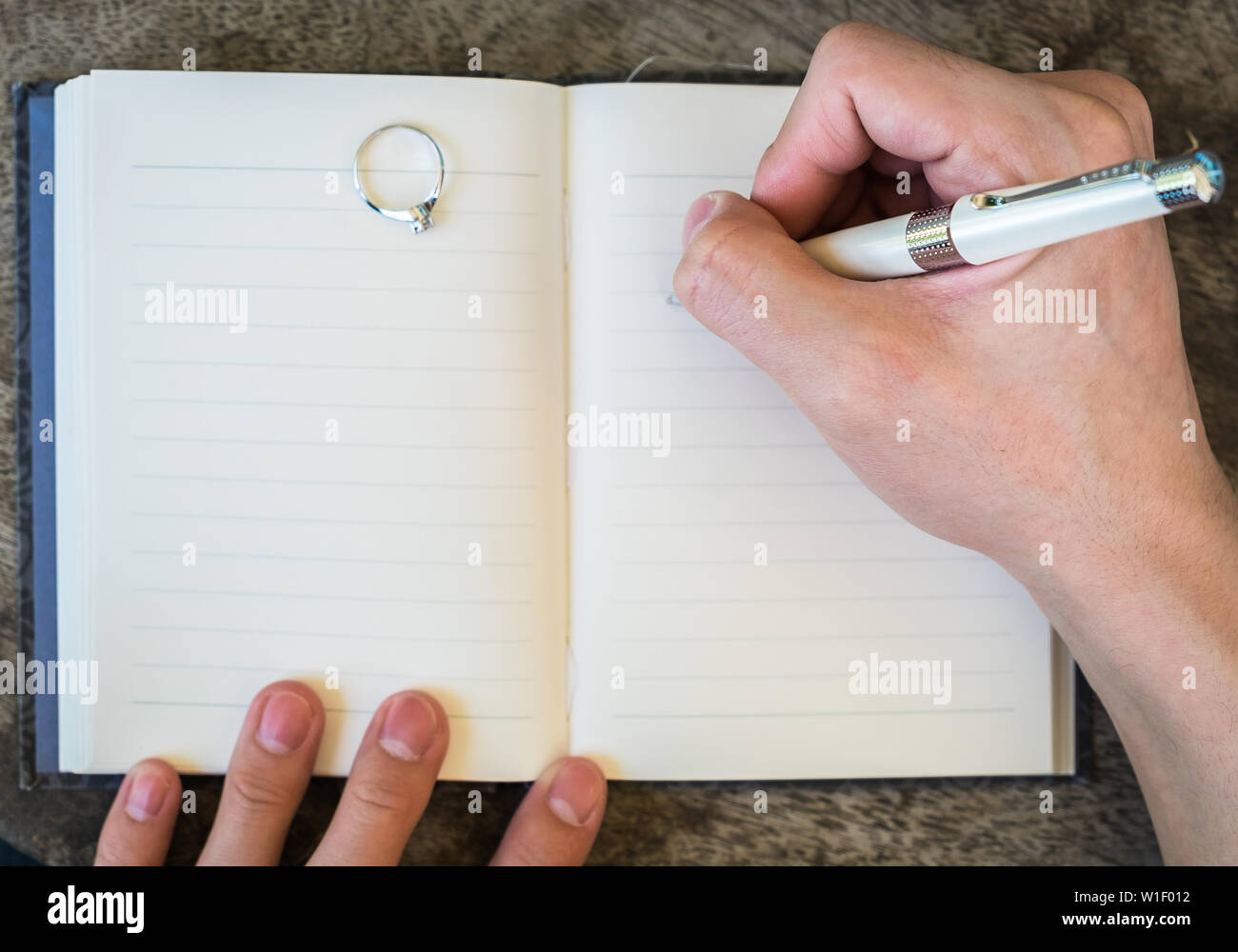 La scrittura a mano penna bianca notebook con anello di diamante in memoria Foto Stock