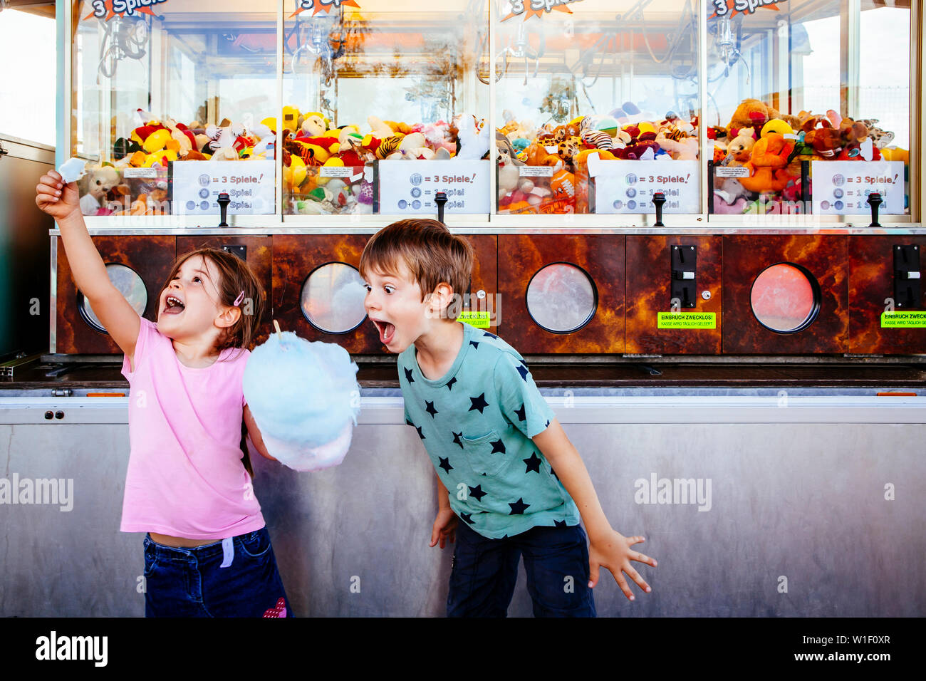 Foto di un fratello e una sorella di mangiare un Big caramella di cotone in un parco di divertimenti. Foto Stock