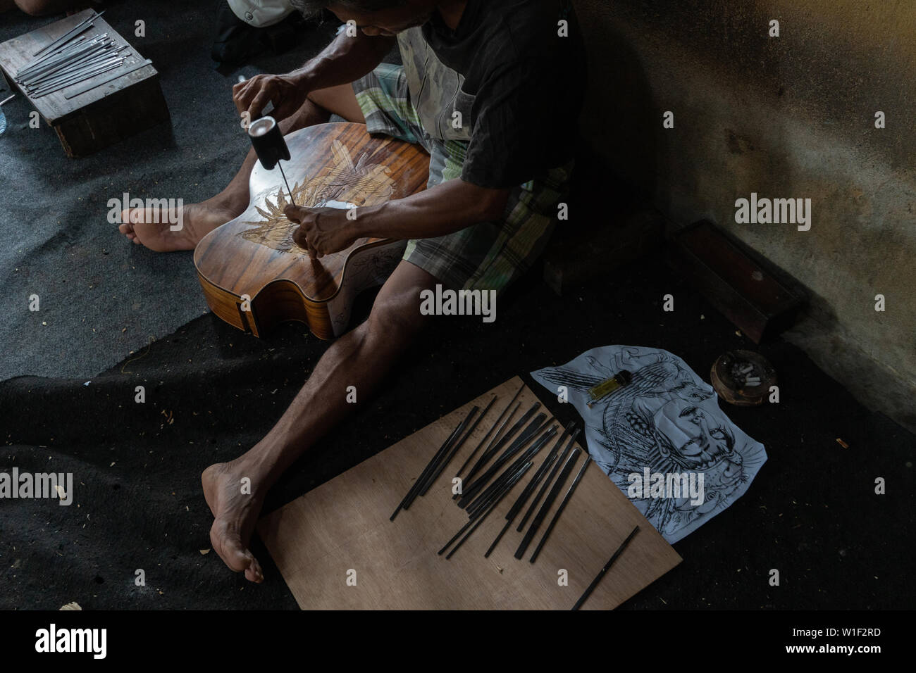 GIANYAR,BALI/INDONESIA-30 MAGGIO 2019: una chitarra artigiano sono carving a chitarre classiche in legno in una chitarra in legno officina di proprietà di I Wayan rimorchiatore Foto Stock