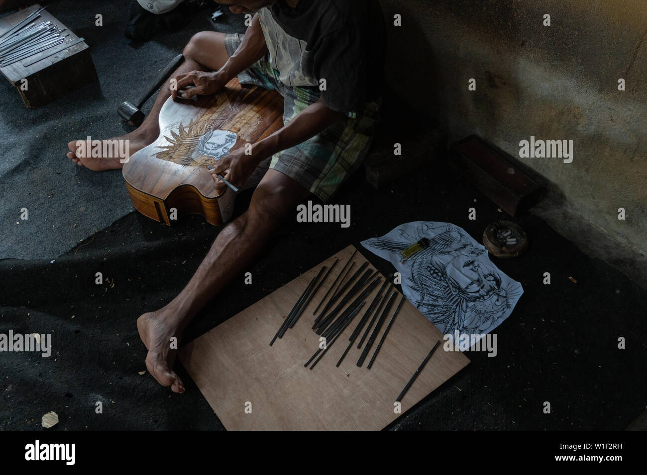 GIANYAR,BALI/INDONESIA-30 MAGGIO 2019: una chitarra artigiano sono carving a chitarre classiche in legno in una chitarra in legno officina di proprietà di I Wayan rimorchiatore Foto Stock