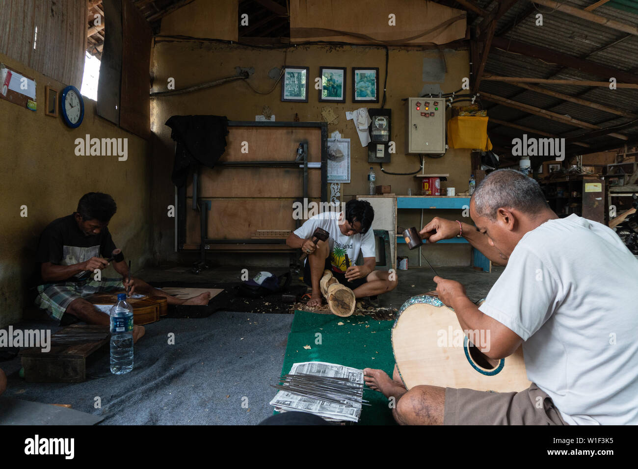 GIANYAR,BALI/INDONESIA-30 MAGGIO 2019: alcuni artigiani di chitarra sono carving a chitarre classiche in legno in una chitarra in legno officina di proprietà di I Wayan Foto Stock