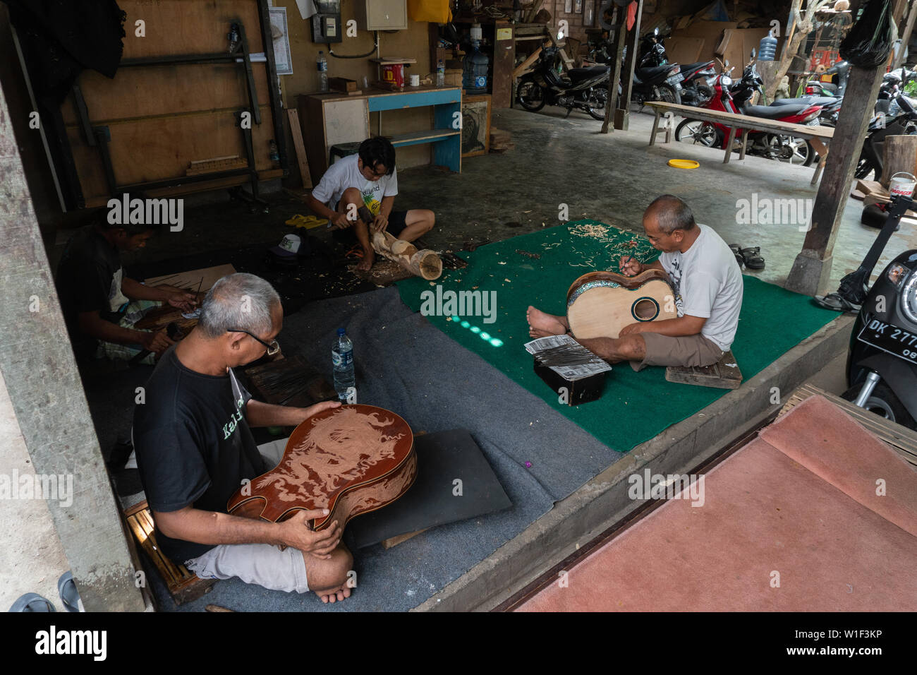 GIANYAR,BALI/INDONESIA-30 MAGGIO 2019: alcuni artigiani di chitarra sono carving a chitarre classiche in legno in una chitarra in legno officina di proprietà di I Wayan Foto Stock