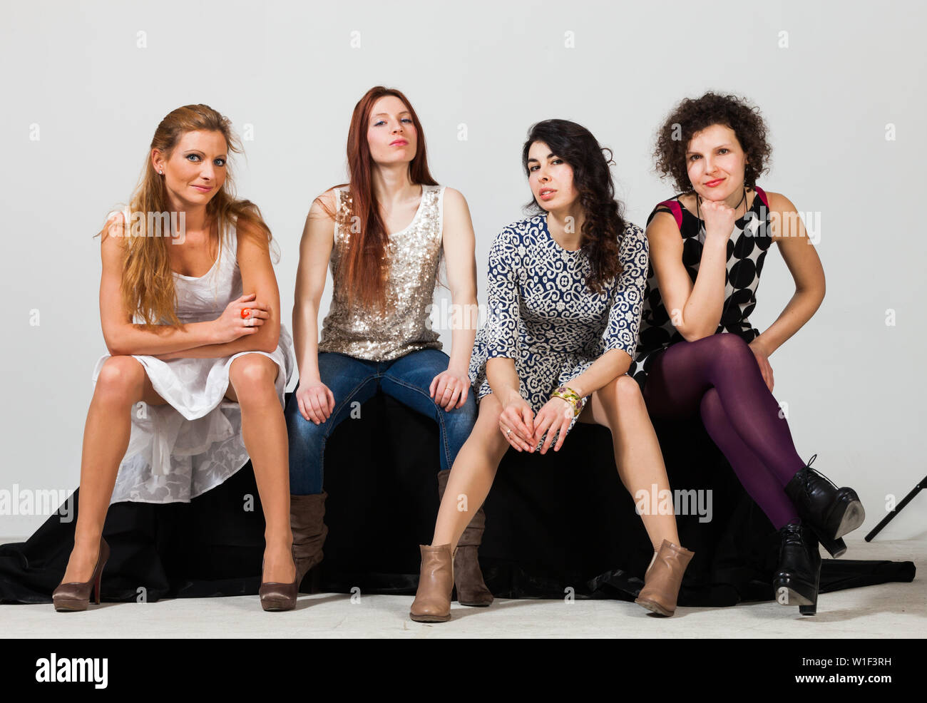 Quattro belle donne pongono insieme in studio Foto Stock