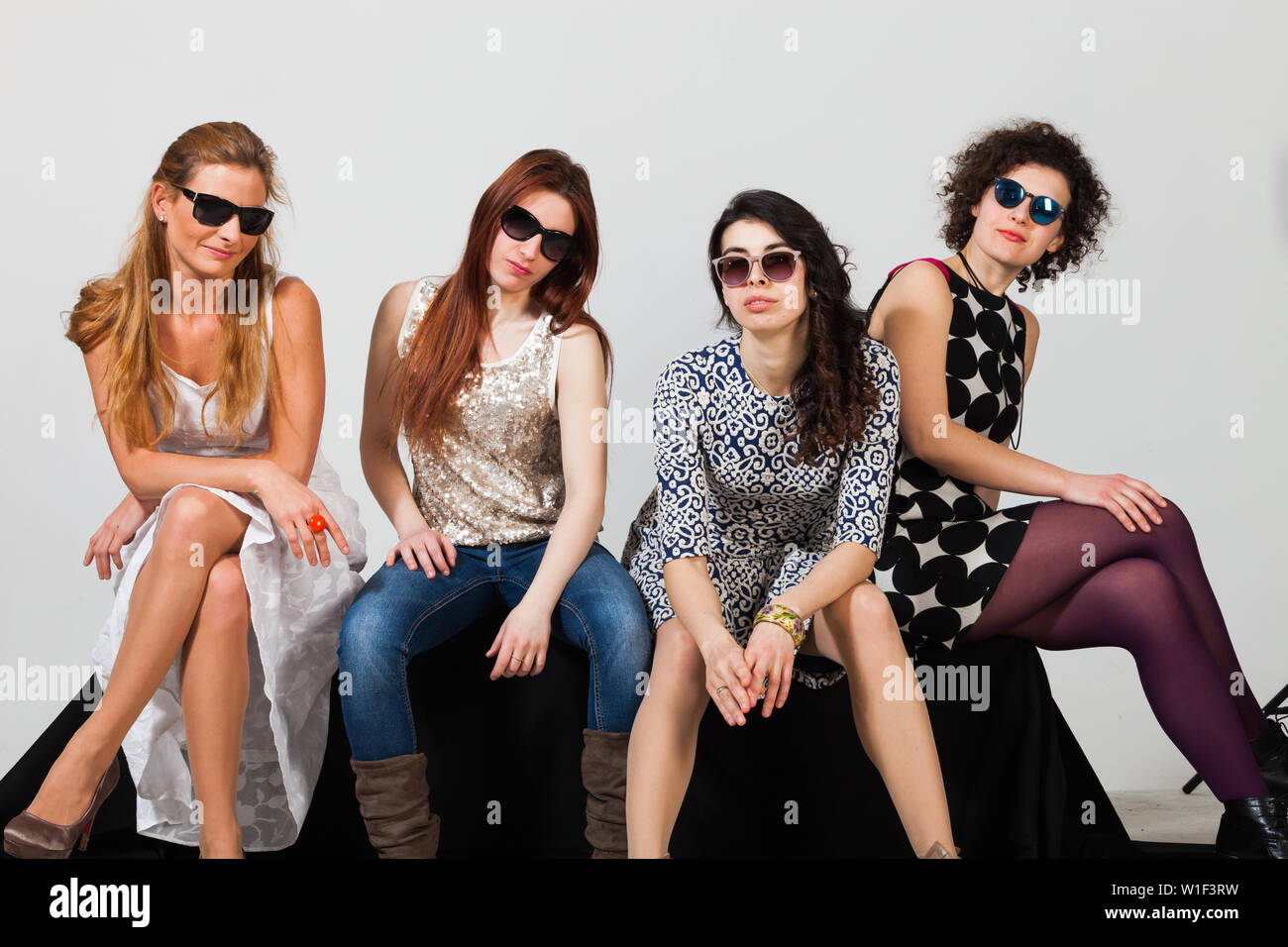 Quattro belle donne pongono insieme in studio Foto Stock