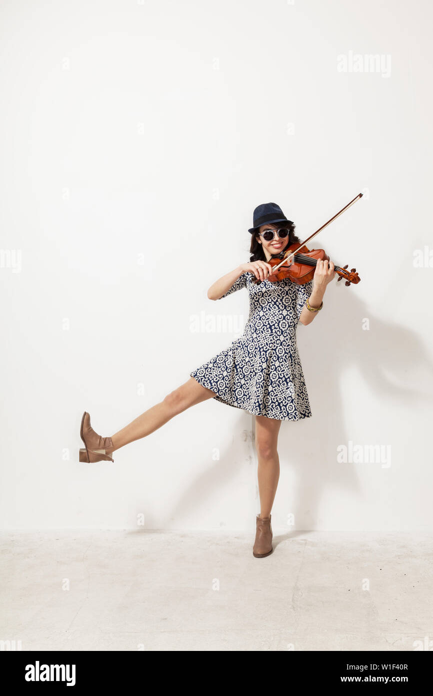 Giovane donna con occhiali scuri e un violino in mano Foto Stock