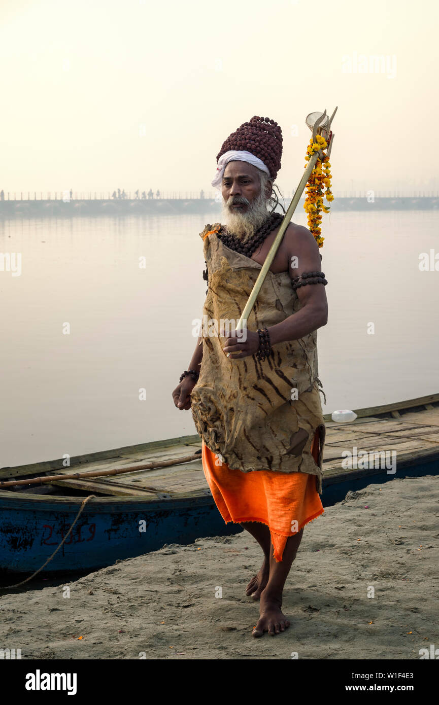 Roma baba con trident e tagete garland sul Gange riverbank all'alba, per il solo uso editoriale, di Allahabad Kumbh Mela, più grande del mondo relig Foto Stock