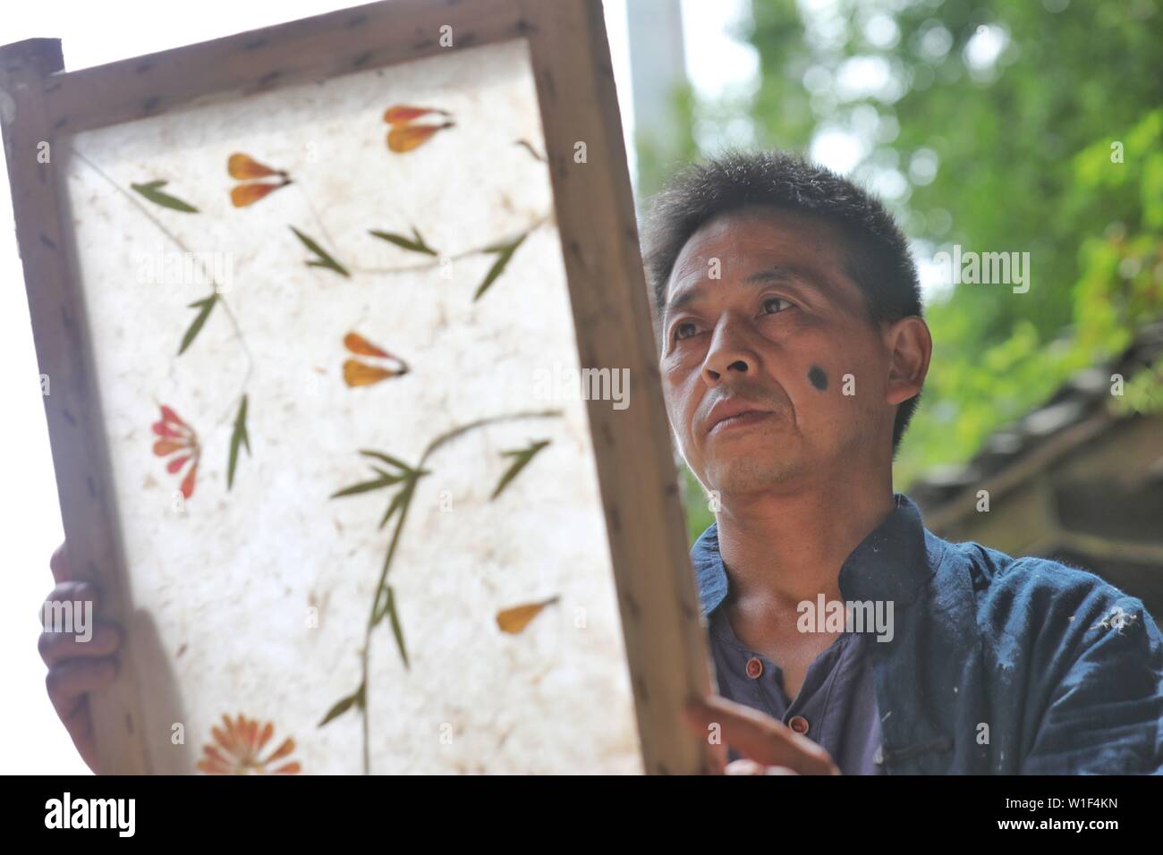 Danzhai, della Cina di Guizhou. 1 Luglio, 2019. Un papermaker controlla la carta fatta con tecniche tradizionali nel villaggio Shiqiao di Danzhai County, a sud-ovest della Cina di Guizhou, 1 luglio 2019. Villaggio Shiqiao è famosa per il nazionale patrimonio culturale immateriale della tradizionale produzione di carta. In questi ultimi anni, locale papermakers si sono combinate con le tecniche tradizionali con innovazione culturale, rendendo il mestiere antico di un eye-catcher nel settore del turismo. Credito: Ou Dongqu/Xinhua/Alamy Live News Foto Stock