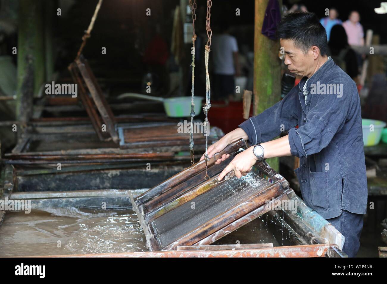 Danzhai, della Cina di Guizhou. 1 Luglio, 2019. Un papermaker rende la carta con le tecniche tradizionali in Shiqiao villaggio di Danzhai County, a sud-ovest della Cina di Guizhou, 1 luglio 2019. Villaggio Shiqiao è famosa per il nazionale patrimonio culturale immateriale della tradizionale produzione di carta. In questi ultimi anni, locale papermakers si sono combinate con le tecniche tradizionali con innovazione culturale, rendendo il mestiere antico di un eye-catcher nel settore del turismo. Credito: Ou Dongqu/Xinhua/Alamy Live News Foto Stock