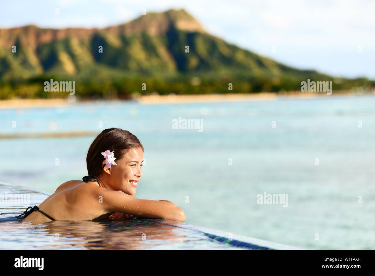 Hawaii spiaggia vacanze viaggi donna nuoto di relax presso la piscina di lusso hotel resort. Asian giovane adulto sulla spiaggia di Waikiki, Honolulu Oahu sulle vacanze esotiche Foto Stock